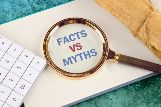 A magnifying glass resting on a paper that reads, "facts vs myths."